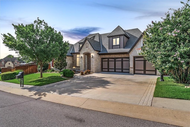 2725 Open Range Rd, Edmond, OK 73034 - view of front facade featuring stone siding, concrete driveway, a garage, and stucco siding