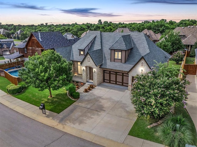 2725 Open Range Rd, Edmond, OK 73034 - view of front of property featuring stone siding, driveway, a shingled roof, and a garage
