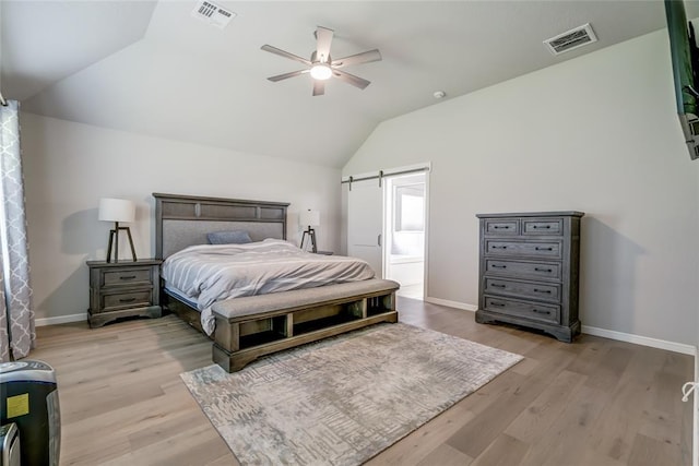 6605 NW 150th Ter, Oklahoma City, OK 73142 - bedroom with vaulted ceiling, light wood-type flooring, ceiling fan, and a barn door