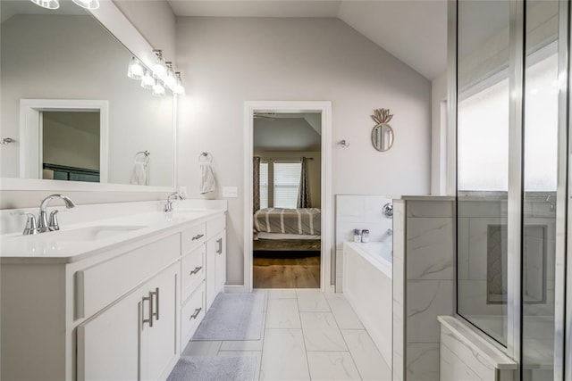 6605 NW 150th Ter, Oklahoma City, OK 73142 - ensuite bathroom with double vanity, a garden tub, marble finish floors, and lofted ceiling
