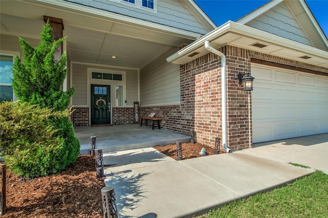 6605 NW 150th Ter, Oklahoma City, OK 73142 - doorway to property featuring brick siding, a porch, concrete driveway, and an attached garage
