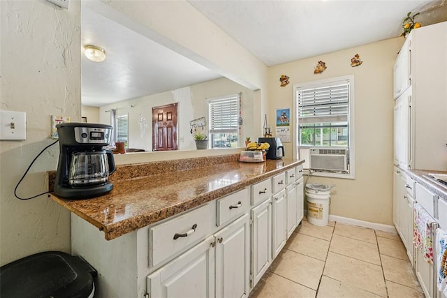 329 SE 58th St, Oklahoma City, OK 73129 - kitchen featuring healthy amount of natural light, white cabinetry, light tile patterned flooring, and cooling unit