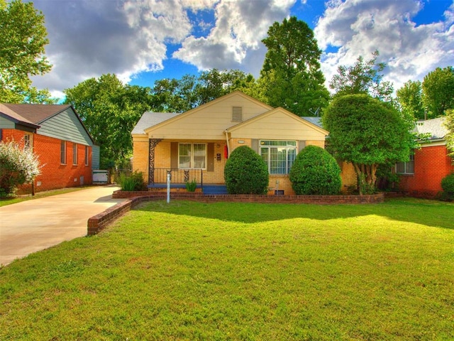 5409 N Walker Ave, Oklahoma City, OK 73118 - view of front of home with brick siding, a porch, a front yard, and driveway