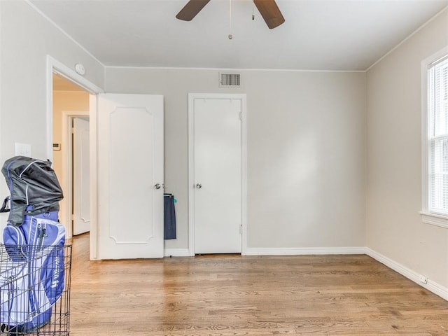 5409 N Walker Ave, Oklahoma City, OK 73118 - unfurnished bedroom featuring multiple windows, light wood-style flooring, ornamental molding, and a ceiling fan