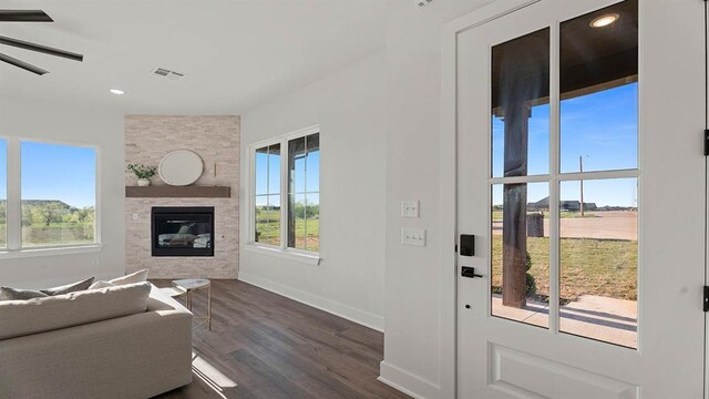 4676 Ranchero Dr, Edmond, OK 73025 - living area with healthy amount of natural light, dark wood finished floors, a large fireplace, recessed lighting, and ceiling fan