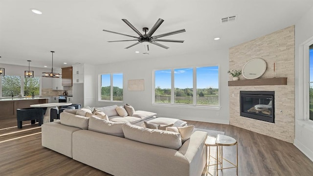 4676 Ranchero Dr, Edmond, OK 73025 - living room featuring plenty of natural light, a ceiling fan, a fireplace, dark wood-type flooring, and recessed lighting