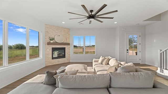 4676 Ranchero Dr, Edmond, OK 73025 - living room featuring ceiling fan, a fireplace, recessed lighting, wood finished floors, and stairs