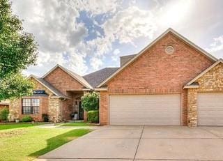 17009 Wales Green Ave, Edmond, OK 73012 - view of front facade with concrete driveway, a garage, a front yard, and brick siding