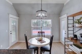 17009 Wales Green Ave, Edmond, OK 73012 - dining space with lofted ceiling, light wood-style flooring, and a chandelier
