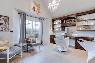 17009 Wales Green Ave, Edmond, OK 73012 - office area with vaulted ceiling, light wood-style floors, and a chandelier