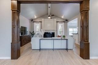 17009 Wales Green Ave, Edmond, OK 73012 - living area with ornate columns, light wood finished floors, and a fireplace