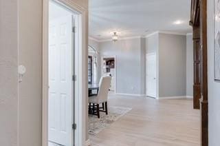 17009 Wales Green Ave, Edmond, OK 73012 - hallway with crown molding and wood finished floors