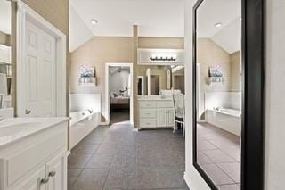 17009 Wales Green Ave, Edmond, OK 73012 - bathroom with vaulted ceiling, vanity, a bath, and tile patterned floors