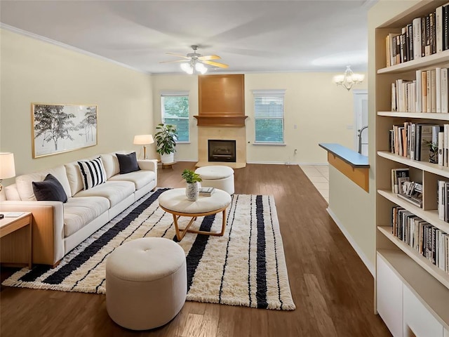 13625 Bell Ave, Oklahoma City, OK 73142 - living room featuring a fireplace, a ceiling fan, wood finished floors, a chandelier, and ornamental molding