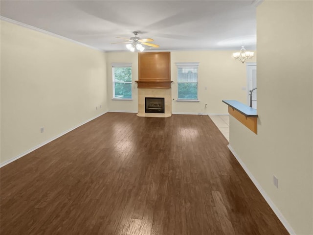 13625 Bell Ave, Oklahoma City, OK 73142 - unfurnished living room with a fireplace with flush hearth, dark wood finished floors, ceiling fan, a chandelier, and ornamental molding