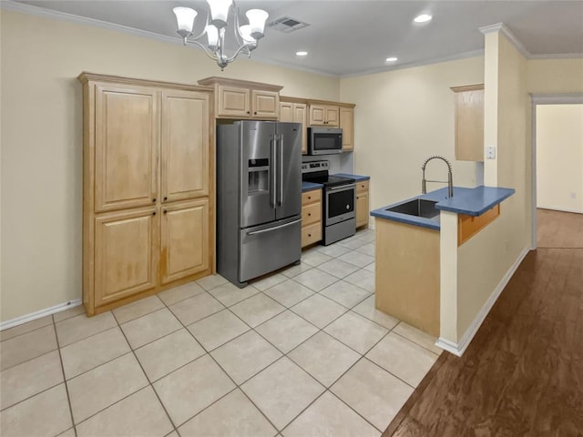13625 Bell Ave, Oklahoma City, OK 73142 - kitchen with stainless steel appliances, dark countertops, crown molding, a peninsula, and a chandelier