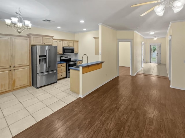 13625 Bell Ave, Oklahoma City, OK 73142 - kitchen featuring appliances with stainless steel finishes, crown molding, dark countertops, a peninsula, and a chandelier
