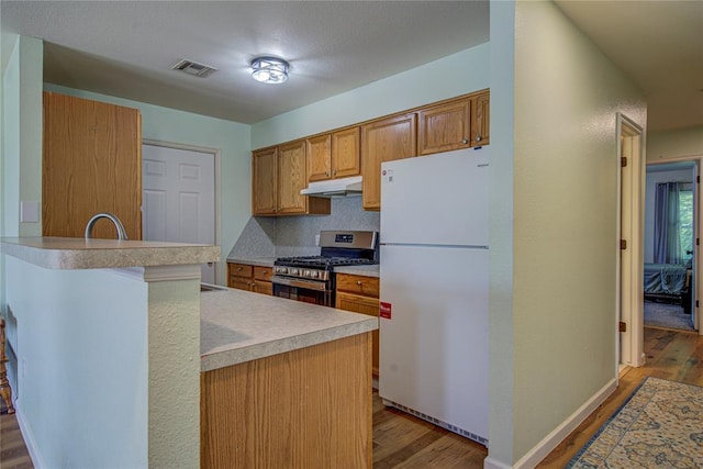 2013 Creekridge Dr, Oklahoma City, OK 73141 - kitchen featuring freestanding refrigerator, gas stove, wood finished floors, light countertops, and under cabinet range hood