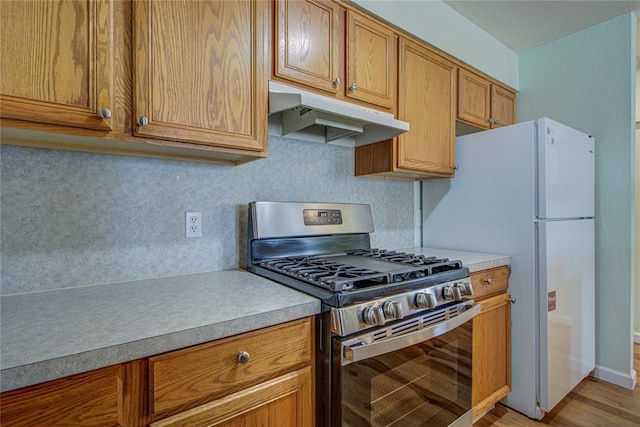 2013 Creekridge Dr, Oklahoma City, OK 73141 - kitchen with stainless steel gas range oven, under cabinet range hood, light countertops, and light wood-type flooring