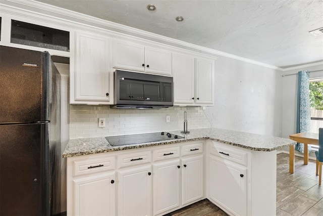 10412 NW 37th St, Yukon, OK 73099 - kitchen with black appliances, a peninsula, tasteful backsplash, white cabinetry, and crown molding