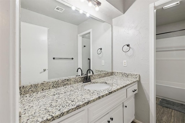 10412 NW 37th St, Yukon, OK 73099 - full bath featuring vanity, shower / bath combination, and wood finished floors