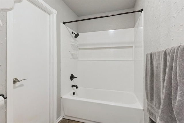 10412 NW 37th St, Yukon, OK 73099 - bathroom featuring shower / washtub combination, a textured wall, and wood finished floors