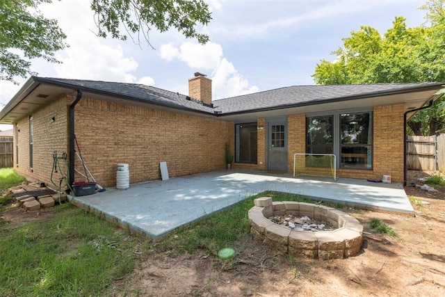 10412 NW 37th St, Yukon, OK 73099 - back of house with a patio area, an outdoor fire pit, brick siding, a chimney, and a shingled roof