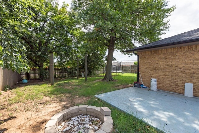 10412 NW 37th St, Yukon, OK 73099 - fenced backyard with a trampoline, a fire pit, and a patio area