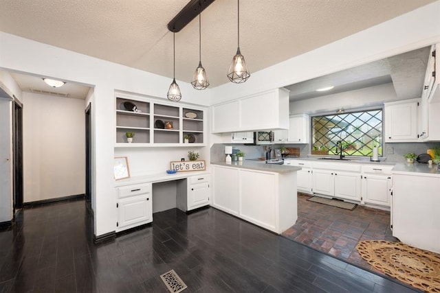10520 Ricky Ln, Midwest City, OK 73130 - kitchen featuring light countertops, white cabinetry, open shelves, built in desk, and a textured ceiling