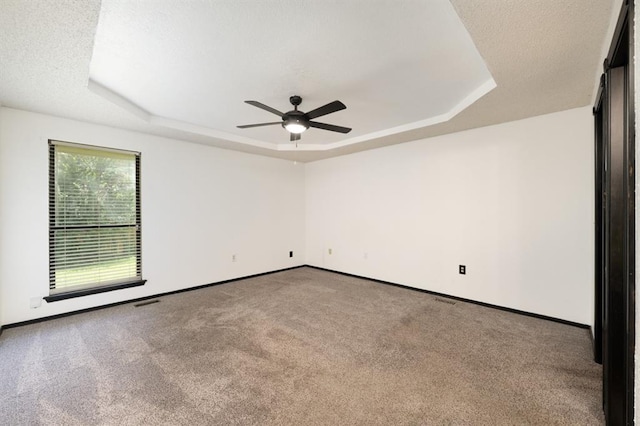 10520 Ricky Ln, Midwest City, OK 73130 - spare room featuring a raised ceiling, carpet, and a ceiling fan