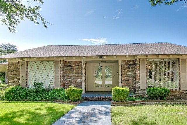 2532 Lancaster Ln, Oklahoma City, OK 73116 - entrance to property featuring brick siding, a shingled roof, a yard, and french doors