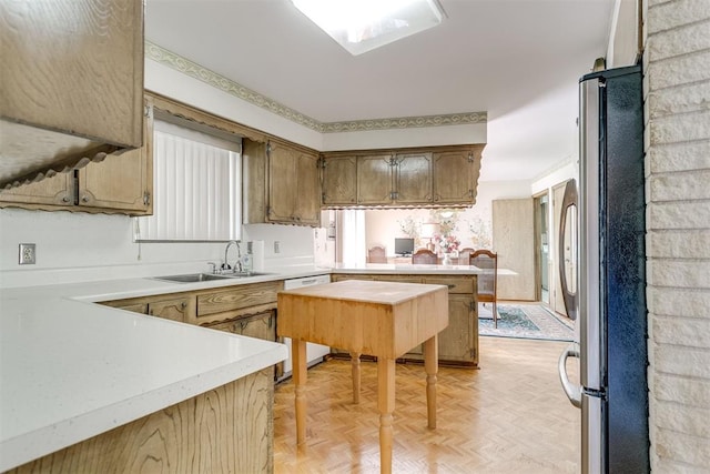2532 Lancaster Ln, Oklahoma City, OK 73116 - kitchen featuring freestanding refrigerator, a peninsula, light countertops, white dishwasher, and brown cabinetry