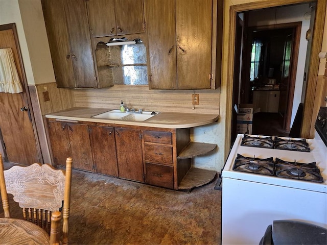621 S 9th St, Yukon, OK 73099 - kitchen with white gas range, light countertops, open shelves, and brown cabinetry