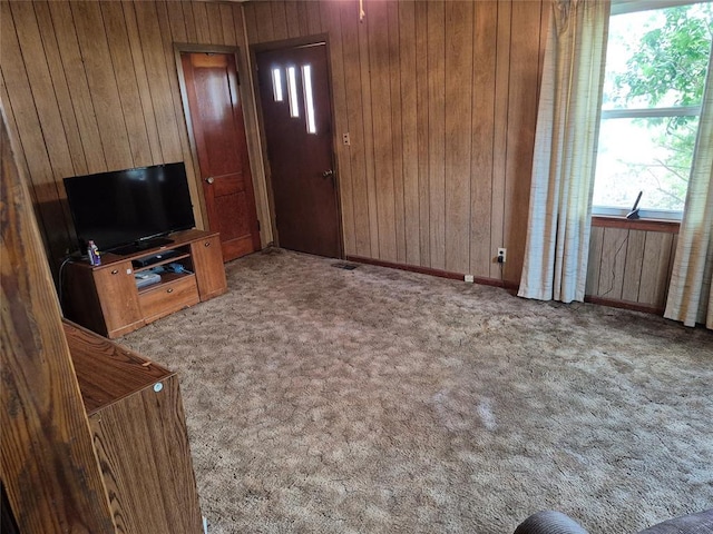 621 S 9th St, Yukon, OK 73099 - unfurnished living room with wooden walls, plenty of natural light, and carpet
