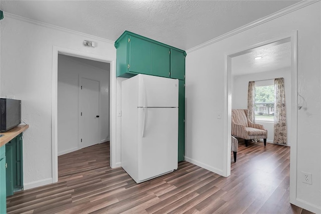 615 N Lowe, Hobart, OK 73651 - kitchen featuring freestanding refrigerator, green cabinets, dark wood-style floors, ornamental molding, and a textured ceiling