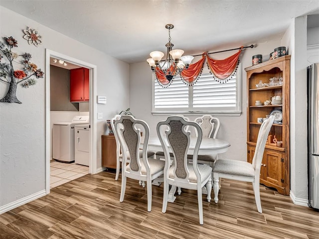 617 Hoehner Ave, Okarche, OK 73762 - dining area with washing machine and clothes dryer, light wood finished floors, and a chandelier