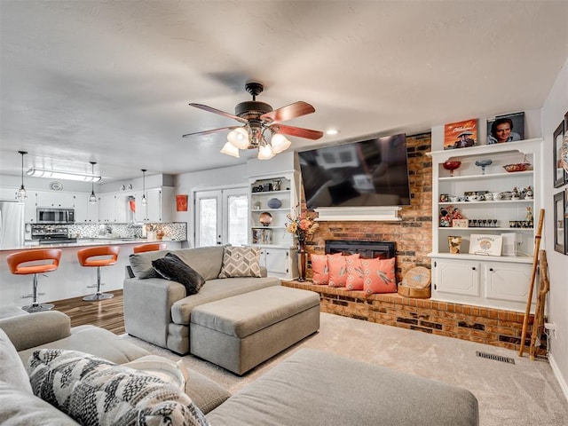 617 Hoehner Ave, Okarche, OK 73762 - carpeted living area featuring ceiling fan and a brick fireplace