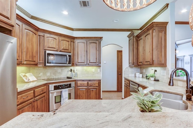825 Silver Tree Dr, Choctaw, OK 73020 - kitchen featuring appliances with stainless steel finishes, crown molding, arched walkways, light stone countertops, and tasteful backsplash