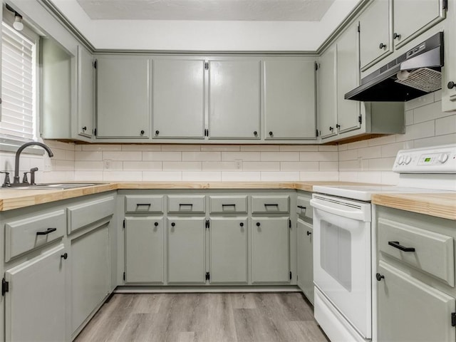 2550 Clarke St, Choctaw, OK 73020 - kitchen featuring electric range, under cabinet range hood, light wood-type flooring, and decorative backsplash