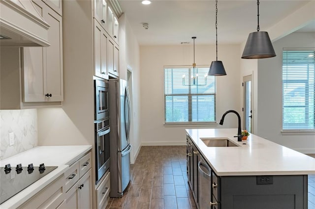 14704 Ashore Dr, Oklahoma City, OK 73142 - kitchen featuring appliances with stainless steel finishes, custom exhaust hood, decorative backsplash, light countertops, and a kitchen island with sink