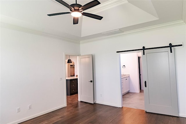 14704 Ashore Dr, Oklahoma City, OK 73142 - unfurnished bedroom with ornamental molding, a barn door, dark wood finished floors, ensuite bath, and a ceiling fan