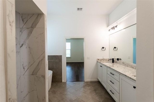 14704 Ashore Dr, Oklahoma City, OK 73142 - bathroom featuring vanity, a freestanding tub, and tile walls
