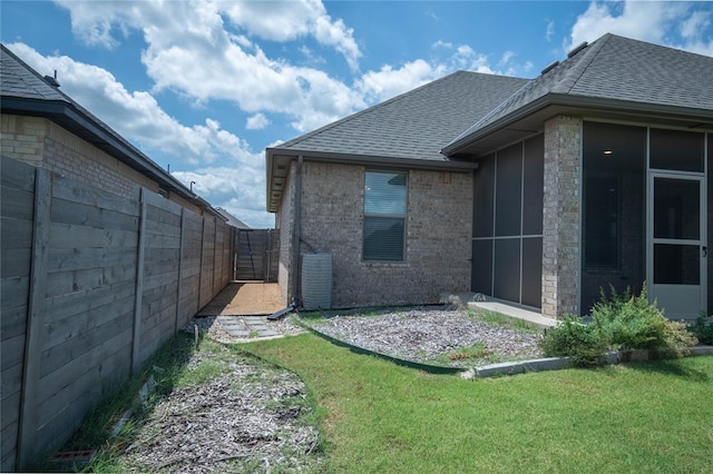 14704 Ashore Dr, Oklahoma City, OK 73142 - back of property featuring a shingled roof, brick siding, a sunroom, and a gate