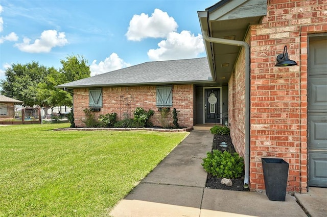 4155 NW Terrace Hills Rd, Piedmont, OK 73078 - view of exterior entry with a yard, brick siding, and roof with shingles