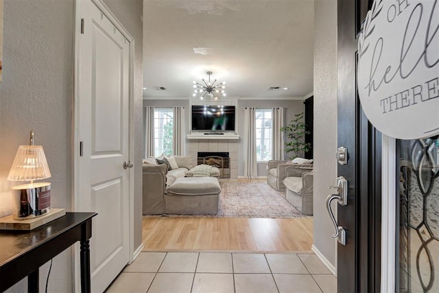 4155 NW Terrace Hills Rd, Piedmont, OK 73078 - entrance foyer featuring crown molding, a fireplace, light tile patterned flooring, and a textured wall