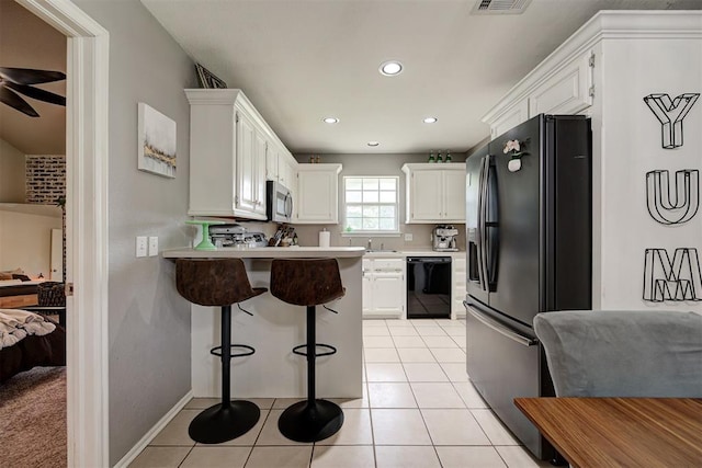 4155 NW Terrace Hills Rd, Piedmont, OK 73078 - kitchen featuring black appliances, a kitchen bar, a peninsula, light countertops, and recessed lighting