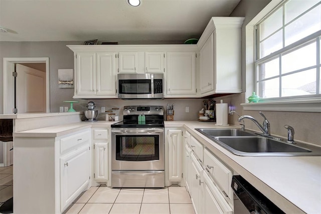4155 NW Terrace Hills Rd, Piedmont, OK 73078 - kitchen featuring appliances with stainless steel finishes, a peninsula, light tile patterned floors, light countertops, and white cabinets