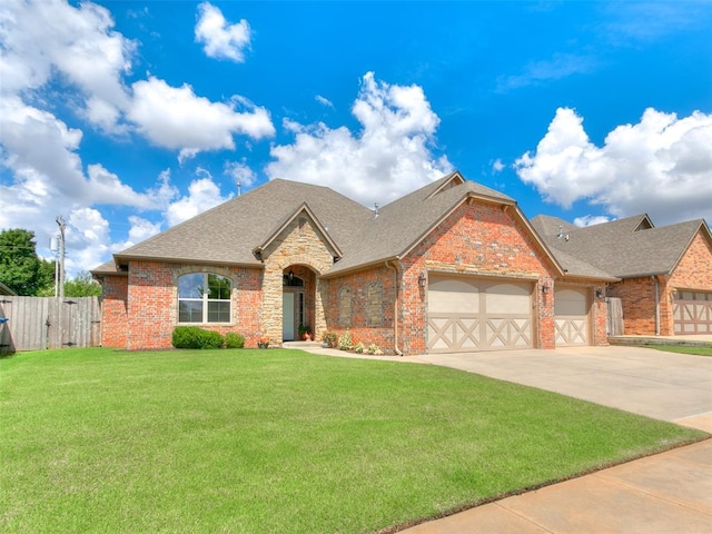 17401 Melville Ln, Edmond, OK 73012 - view of front of property featuring an attached garage, driveway, roof with shingles, brick siding, and a gate
