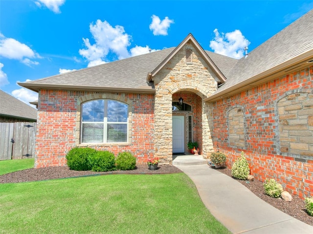 17401 Melville Ln, Edmond, OK 73012 - doorway to property featuring a shingled roof, brick siding, and stone siding