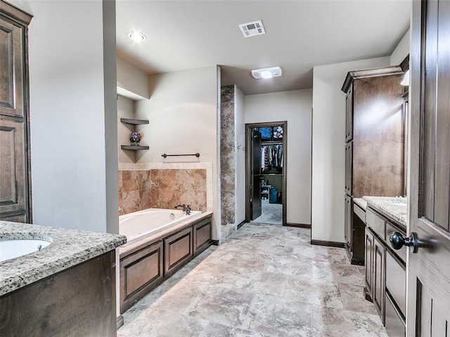 17401 Melville Ln, Edmond, OK 73012 - full bath featuring a garden tub, vanity, a spacious closet, and stone finish floors